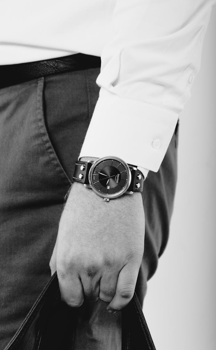 The Art of Drawing Readers In: Your attractive post title goes here Close-up of a man holding a bag, showcasing an elegant wristwatch in a classic monochrome style.