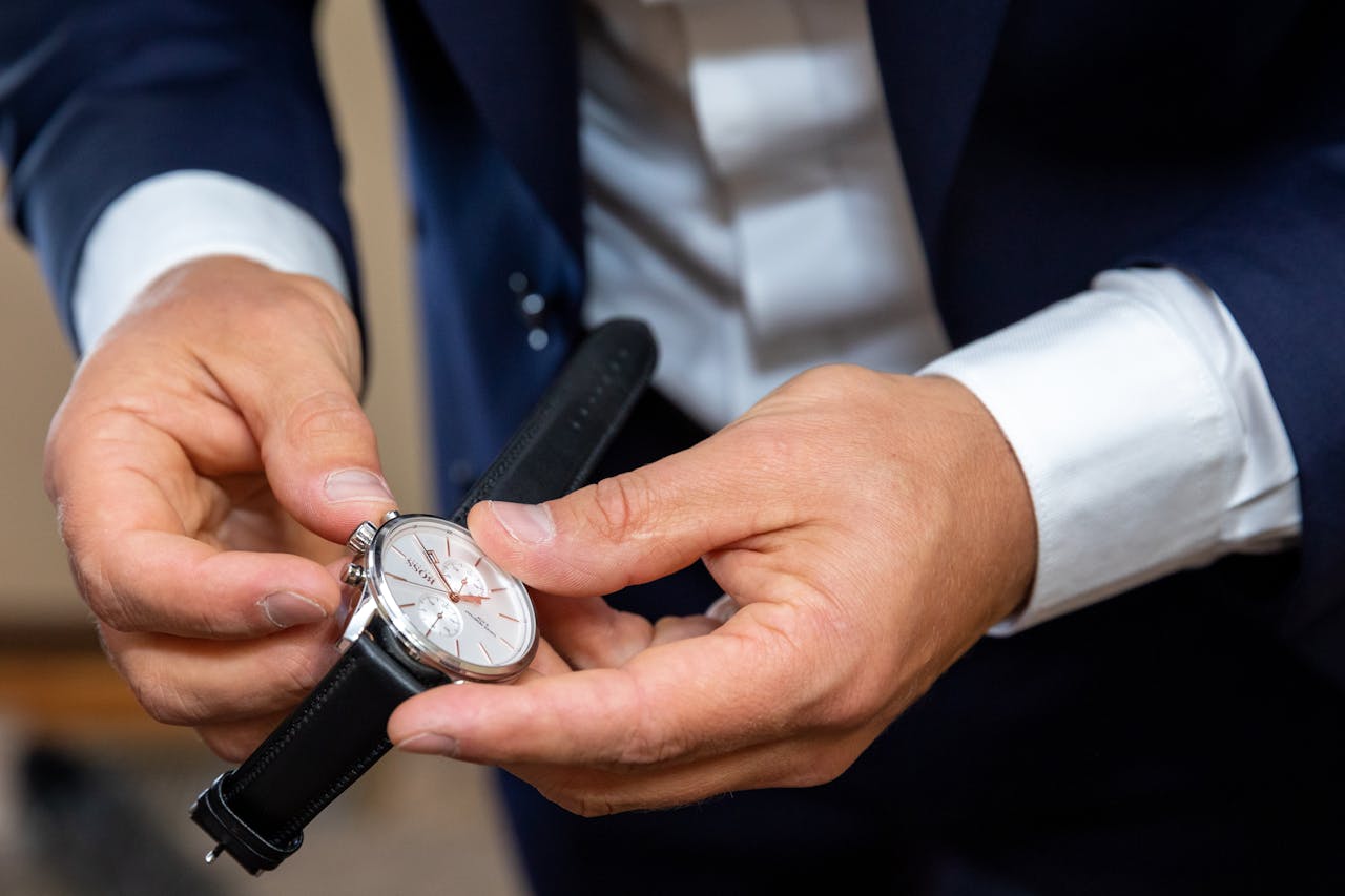 services-04 Close-up of a man's hands adjusting a luxury wristwatch, highlighting sophisticated style.