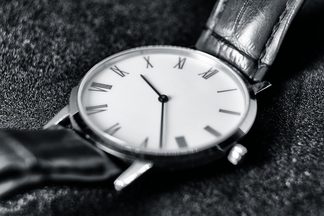 Close-up image of a monochrome wristwatch with Roman numerals, showcasing elegant design.