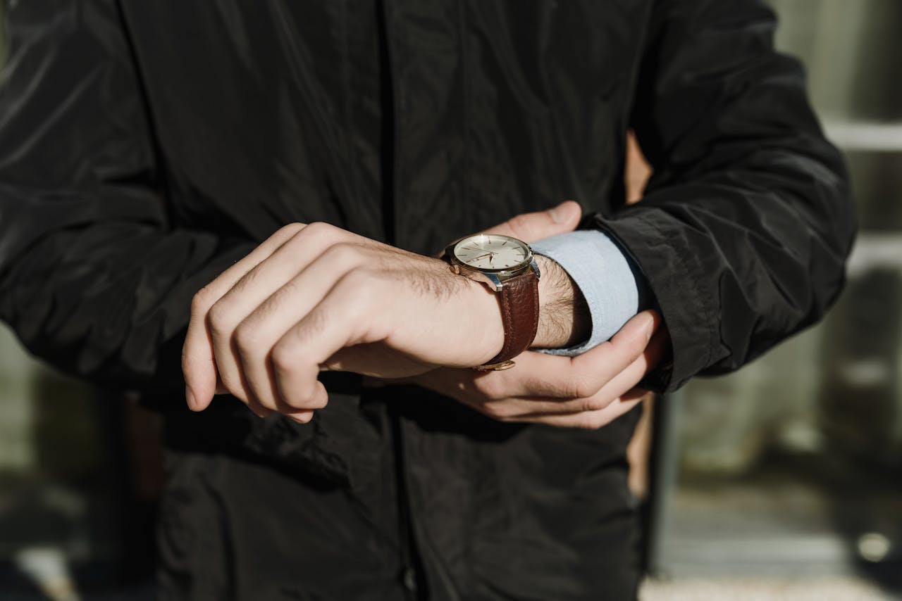 Mastering the First Impression: Your intriguing post title goes here Close-up of a man's hands adjusting a classic leather watch outdoors.